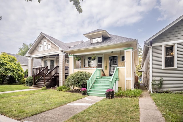 bungalow-style home with covered porch and a front yard