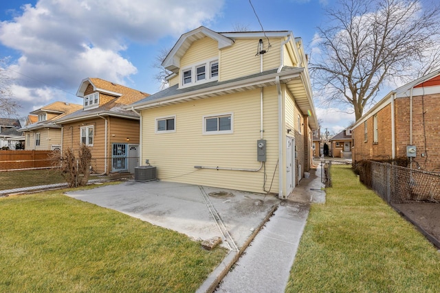 back of property featuring a lawn, cooling unit, and a patio