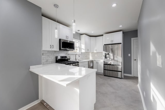 kitchen featuring backsplash, white cabinets, appliances with stainless steel finishes, decorative light fixtures, and kitchen peninsula