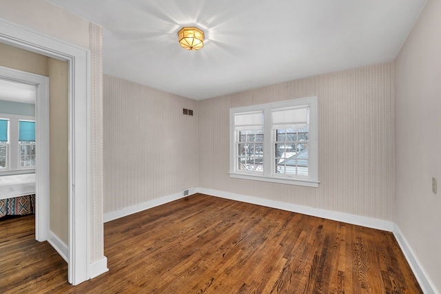 empty room featuring dark hardwood / wood-style floors and plenty of natural light