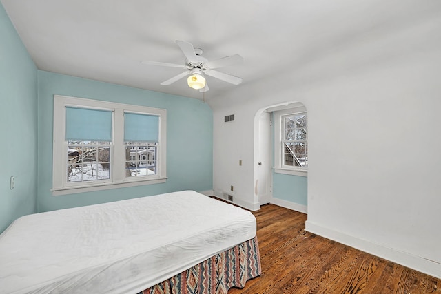 bedroom with dark hardwood / wood-style flooring and ceiling fan