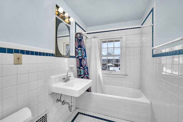 full bathroom with shower / tub combo, sink, tile walls, tile patterned flooring, and toilet