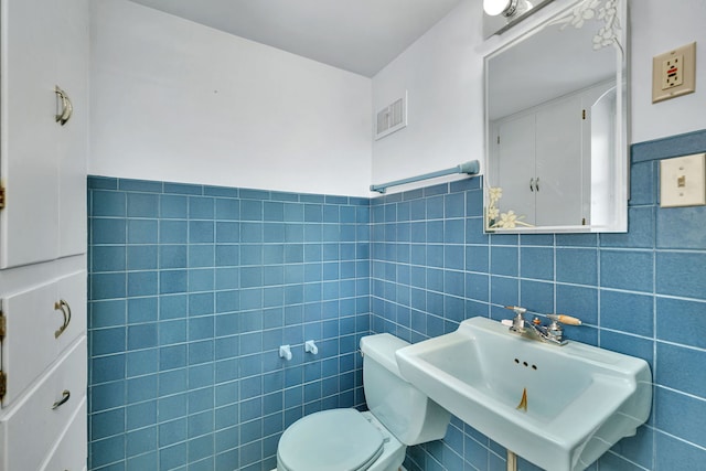 bathroom with sink and tile walls