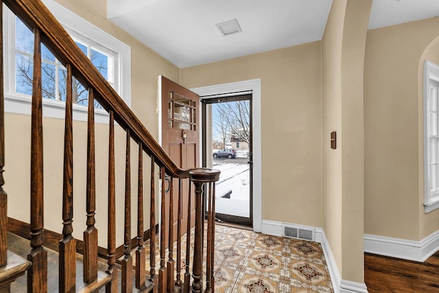 foyer entrance with wood-type flooring and a wealth of natural light