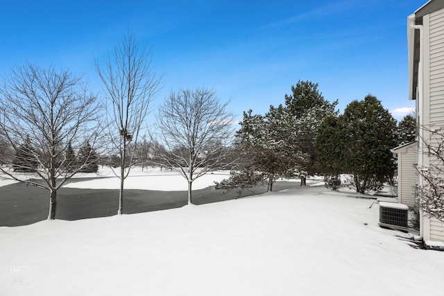 yard covered in snow featuring central AC unit