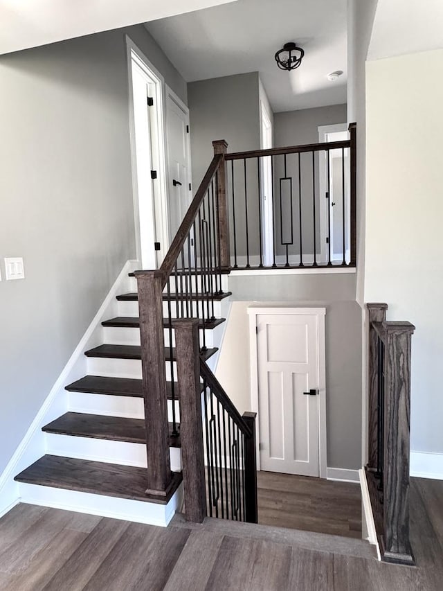 stairs featuring wood finished floors and baseboards