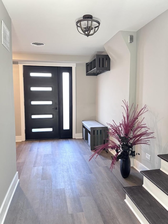 foyer featuring visible vents, baseboards, and wood finished floors