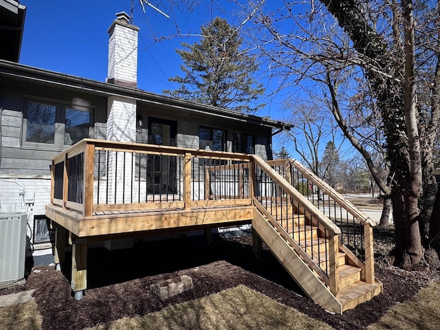 rear view of property featuring central air condition unit, a deck, a chimney, and stairway