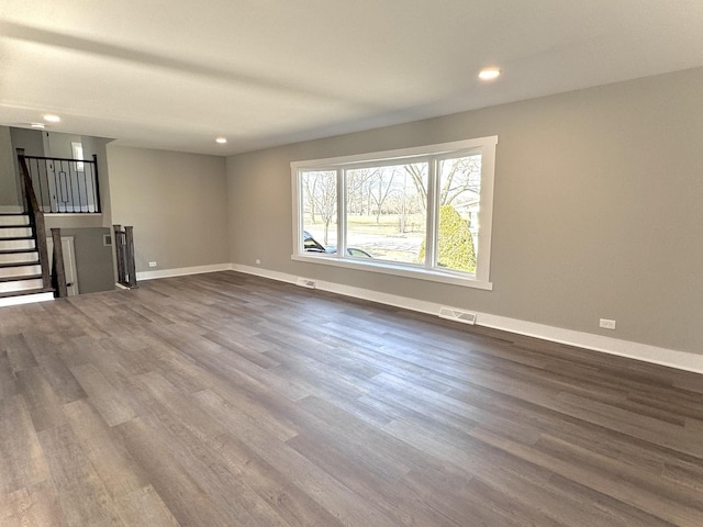 unfurnished living room with stairway, baseboards, visible vents, dark wood finished floors, and recessed lighting