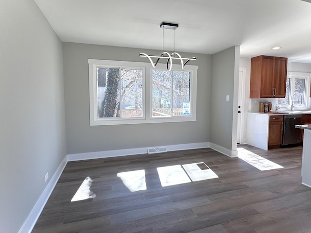 unfurnished dining area featuring a chandelier, visible vents, baseboards, and dark wood-style floors