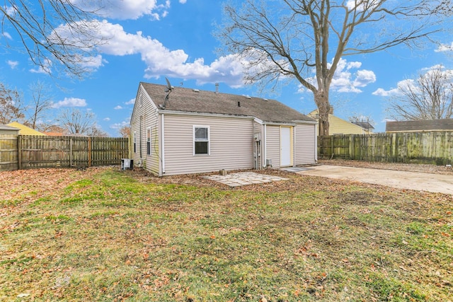 rear view of property featuring a yard and a patio area