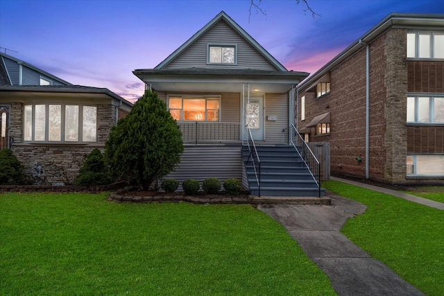 bungalow-style home with covered porch and a lawn