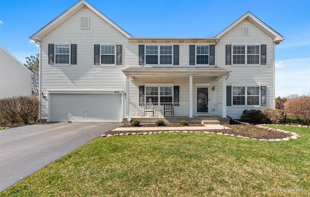 view of front of property featuring a porch, a garage, and a front lawn