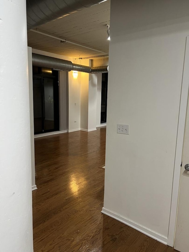 corridor with dark hardwood / wood-style flooring