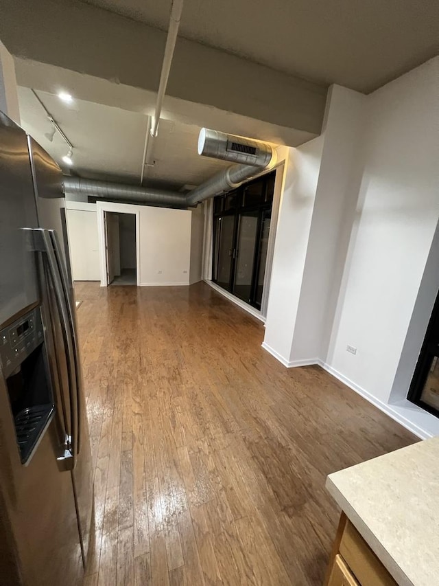 kitchen featuring rail lighting, stainless steel refrigerator with ice dispenser, and hardwood / wood-style flooring