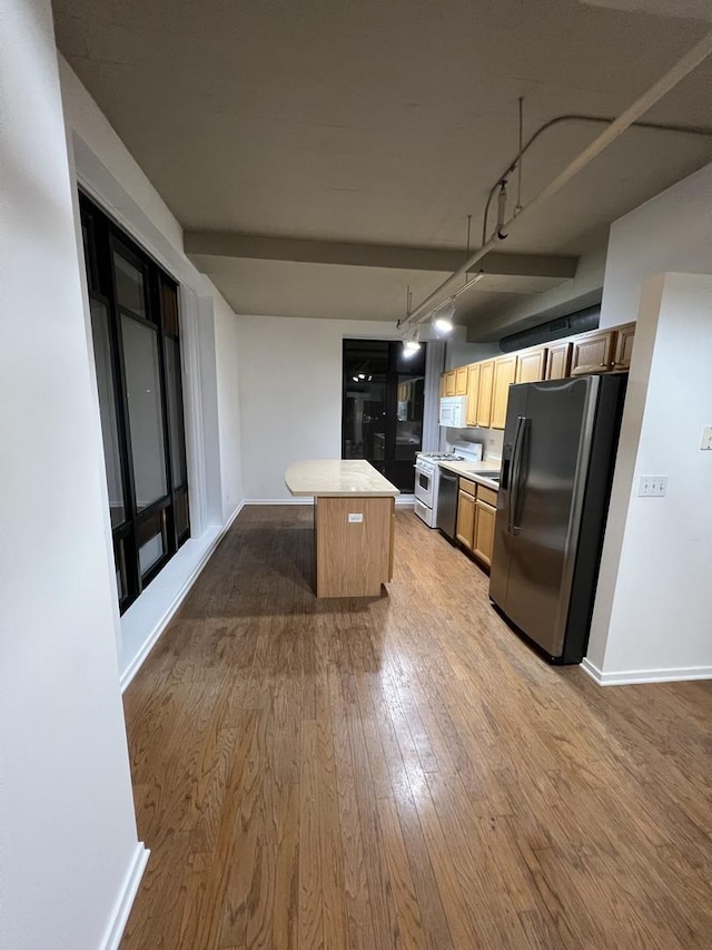 kitchen with stainless steel fridge with ice dispenser, a center island, range, and wood-type flooring