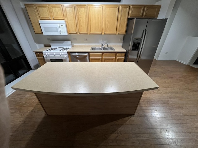 kitchen featuring sink, a center island, stainless steel appliances, and wood-type flooring