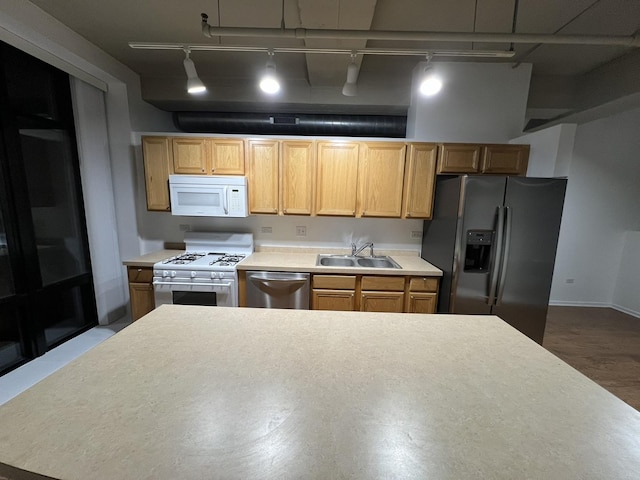 kitchen featuring wood-type flooring, appliances with stainless steel finishes, track lighting, and sink