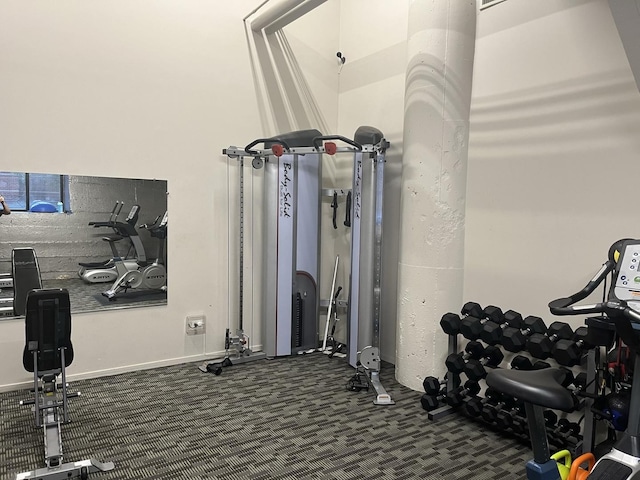 exercise room featuring dark carpet