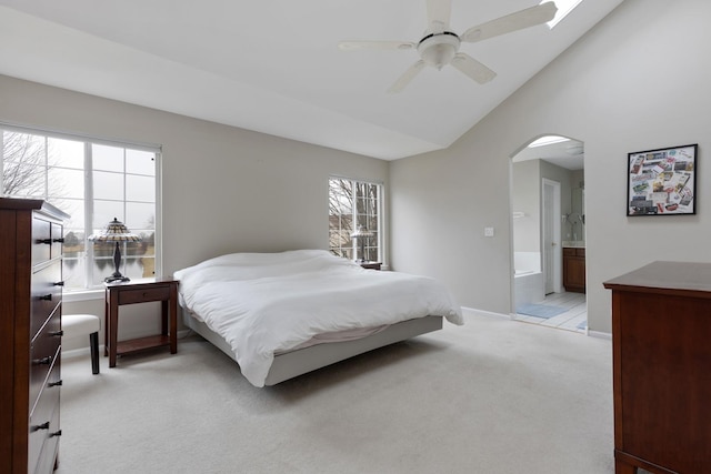 bedroom with connected bathroom, ceiling fan, light carpet, and lofted ceiling