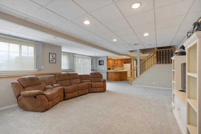 living room with light carpet and a drop ceiling