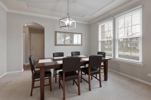 carpeted dining room with crown molding, a wealth of natural light, and an inviting chandelier