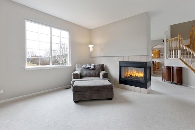 sitting room featuring a tile fireplace and carpet flooring