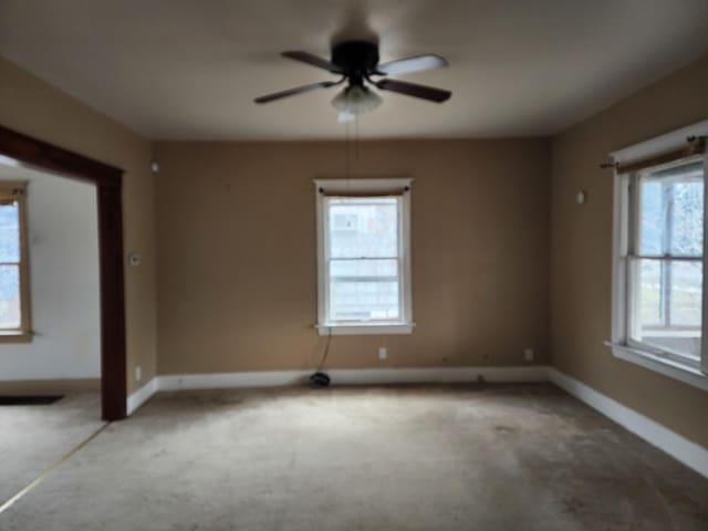 carpeted spare room featuring ceiling fan