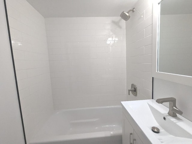 bathroom featuring vanity and tiled shower / bath