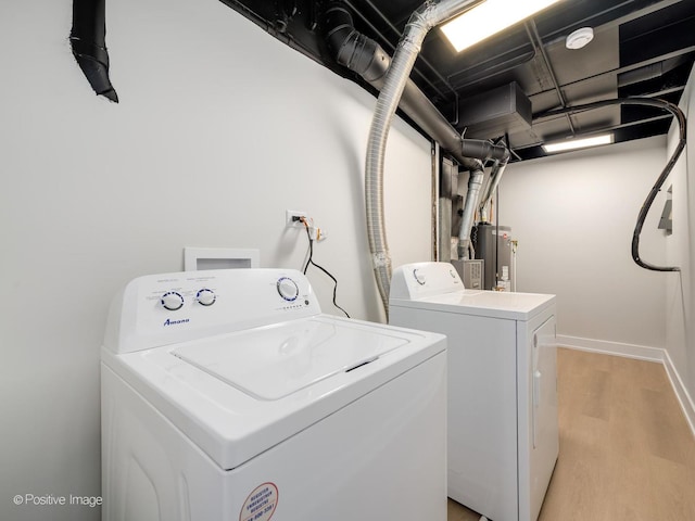 clothes washing area featuring gas water heater, independent washer and dryer, and light hardwood / wood-style floors