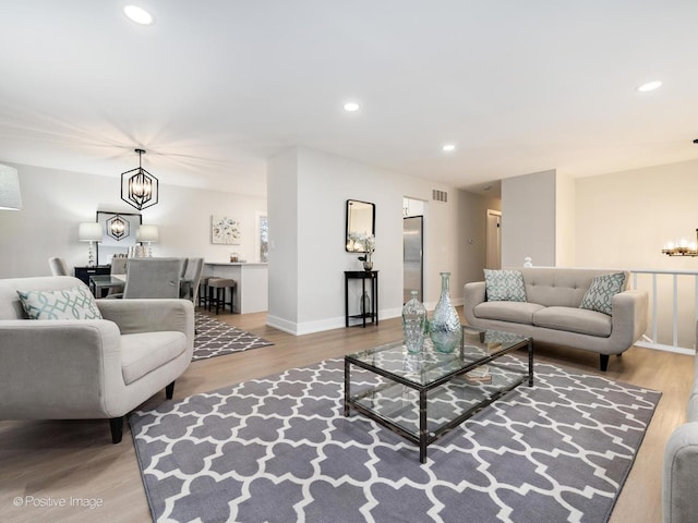 living room featuring an inviting chandelier and light hardwood / wood-style flooring