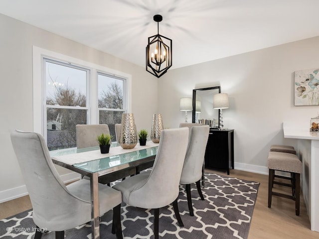 dining room with hardwood / wood-style floors and a notable chandelier