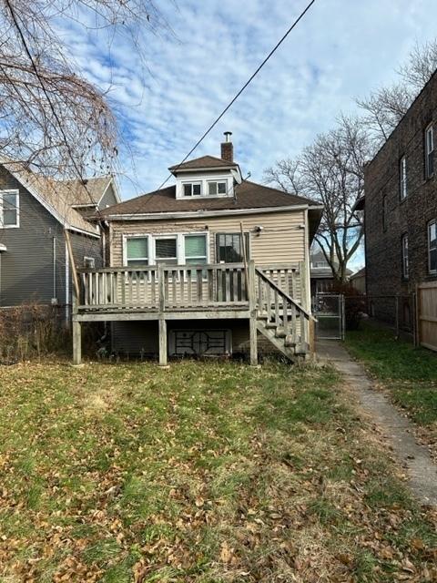 back of property featuring a yard and a deck