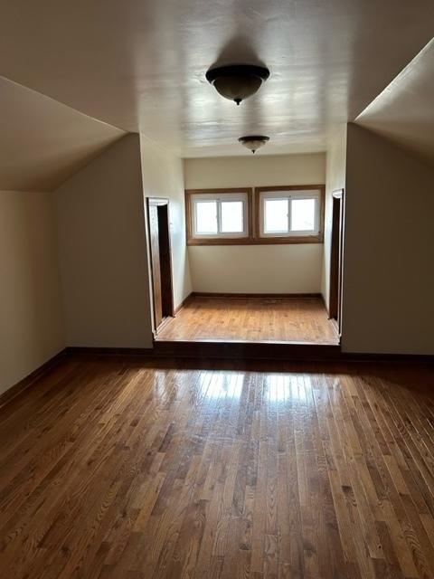 bonus room with vaulted ceiling and light hardwood / wood-style flooring