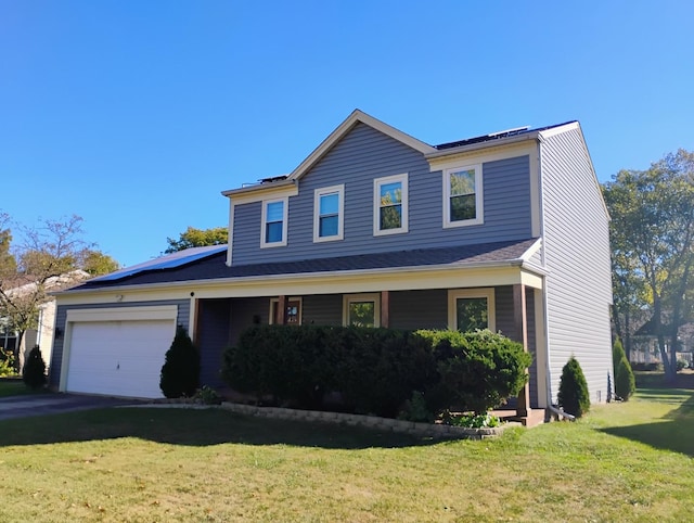 view of front of property with solar panels, a garage, and a front lawn