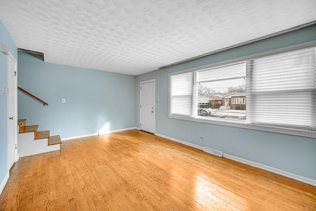 interior space with a textured ceiling and light wood-type flooring