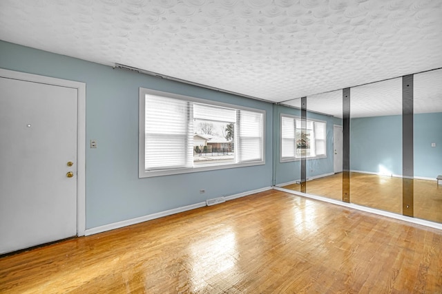 foyer with light hardwood / wood-style floors and a textured ceiling