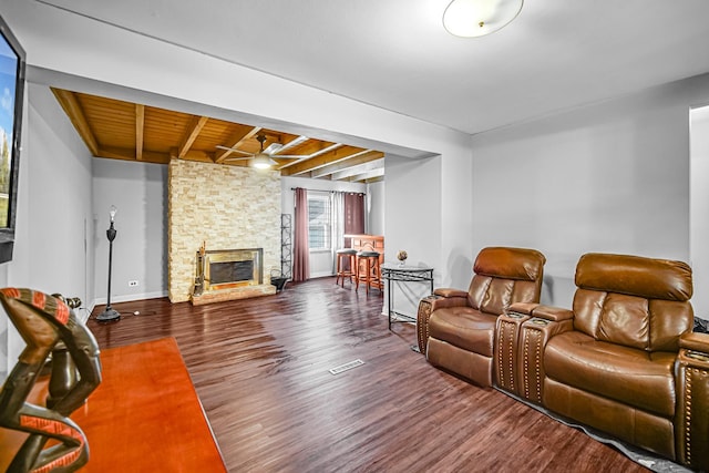 living room with hardwood / wood-style floors, beam ceiling, wooden ceiling, and a fireplace