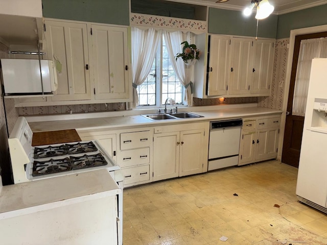 kitchen featuring white appliances, white cabinetry, crown molding, and sink