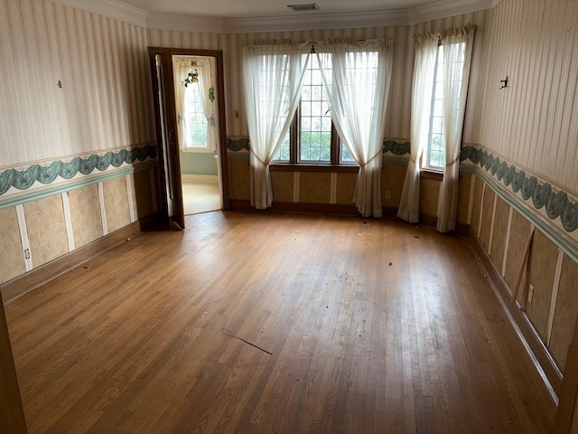 empty room featuring ornamental molding and hardwood / wood-style flooring