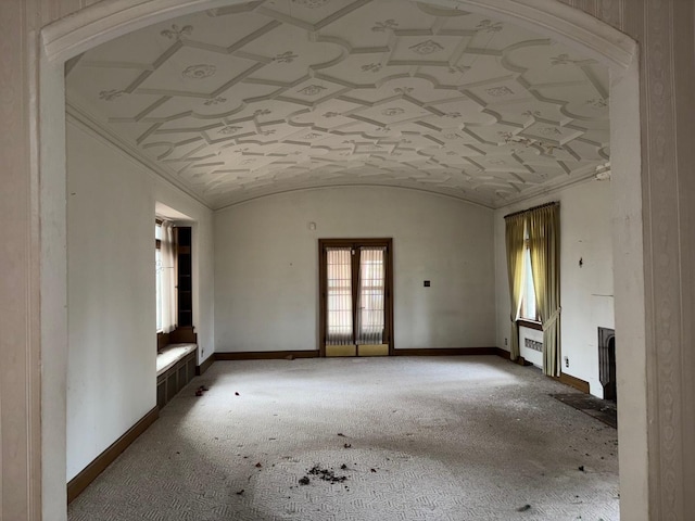 empty room with radiator heating unit, lofted ceiling, and brick ceiling