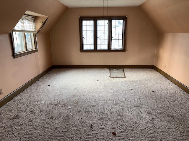 bonus room featuring plenty of natural light, lofted ceiling, and carpet floors