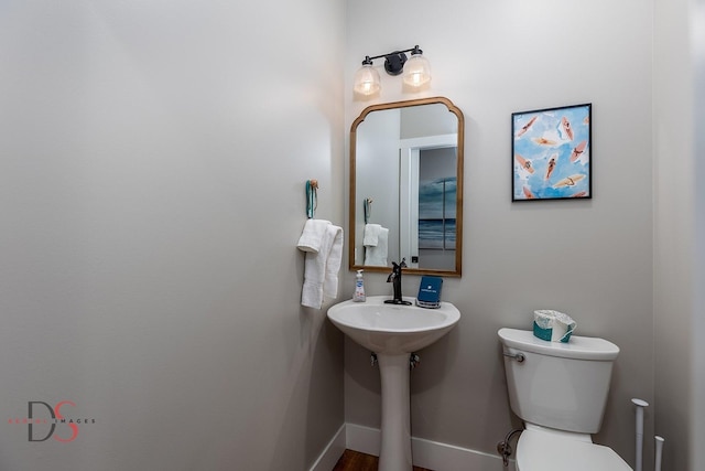 bathroom with hardwood / wood-style flooring and toilet