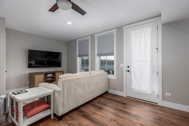 living room featuring ceiling fan and dark hardwood / wood-style floors