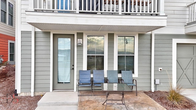 property entrance with a balcony and a patio