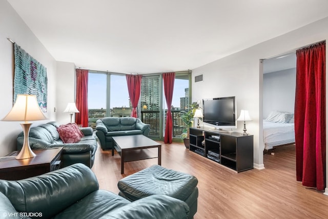 living room with light hardwood / wood-style flooring and a wall of windows