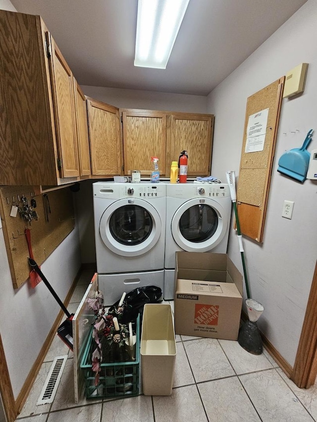 laundry area featuring cabinets, washer and dryer, and light tile patterned flooring