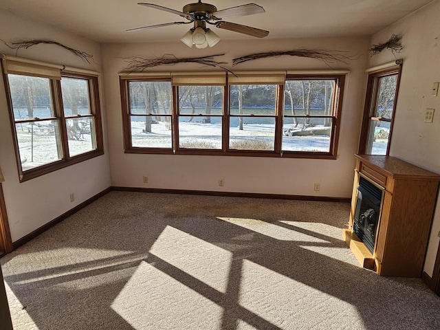 unfurnished living room with carpet and ceiling fan