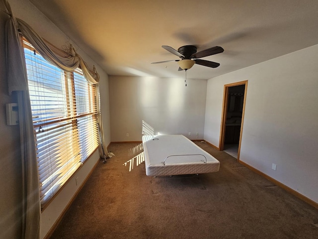 unfurnished bedroom featuring dark carpet and ceiling fan