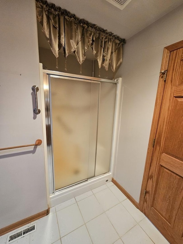 bathroom with tile patterned floors and walk in shower